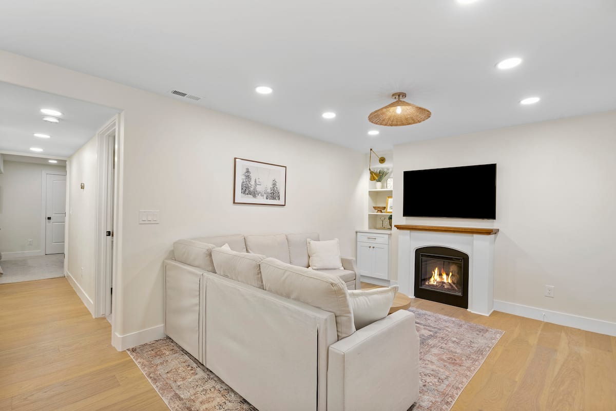 Living room with sectional, fireplace and wall-mounted TV